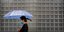 Γυναίκα στην Κίνα με ομπρέλα και μάσκα