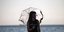 Γυναίκα με μάσκα και ομπρέλα στην Παραλία Θεσσαλονίκης