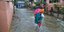 Γυναίκα κρατά αγκαλιά το παιδί της σε πλημμύρες στην Ινδία