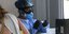 Γυναίκα με στολή και μάσκα πραγματοποιεί τεστ κορωνοϊού στην Αττική