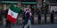 Μεξικανός με σημαία περπατά μπροστά σε αστυνομικούς