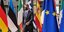 Ο Κυριάκος Μητσοτάκης περπατά ανάμεσα από σημαίες χωρών της ΕΕ φορώντας μάσκα