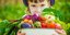 Παιδί κρατά ένα μπολ με φρέσκα λαχανικά