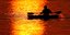 Ενας άνδρας κωπηλατεί σε λίμνη των ΗΠΑ στο ηλιοβασίλεμα 