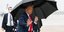 Ο Τραμπ με ομπρέλα χαιρετάει κόσμο