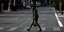 Μια κοπέλα περπατά στους άδειους δρόμους της Αθήνας κατά το lockdown