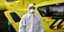 Άνδρας των υπηρεσιών υγείας στην Ολλανδία με στολή και μάσκα κατά την αερομεταφορά ασθενών Covid στη Γερμανία