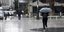 Γυναίκα περπατά κρατώντας ομπρέλα στην βροχή