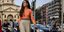 Γυναίκα στο δρόμο με πορτοκαλί τοπ και μπεζ παντελόνι