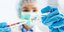 Νοσοκόμα με μάσκα και γάντια κρατά μια σύριγγα εμβολίου