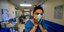 Νοσοκόμα με μάσκα κρατάει το πρόσωπό της με απόγνωση στην Ιταλία