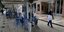 Γυναίκα περνά δίπλα από στοιβαγμένες καρέκλες 