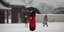 Γυναίκα με μάσκα και ομπρέλα στο χιόνι, στη Νότια Κορέα