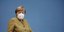 Η καγκελάριος Άνγκελα Μέρκελ με μουσταρδί ταγέρ και μάσκα προστασίας από τον κορωνοϊό