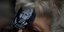Γυναίκα με κονκάρδα του Τζούλιαν Ασάνζ, φιμωμένου με την αμερικανική σημαία