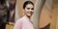 Η Σελένα Γκόμεζ με μπλούζα με ψηλό λαιμό χαμογελά