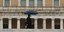 άνδρας περπατά κρατώντας ομπρέλα στην Αθήνα