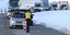 Αστυνομικός μπροστά από ουρά αυτοκινήτων σε περιοχή με χιόνια στην Αυστρία