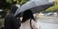 γυναίκα κρατά ομπρέλα στη βροχή