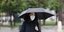 Γυναίκα περπατά κρατώντας ομπρέλα