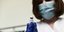 Μια υγειονομικός κρατά ένα μπουκαλάκι εμβολίου στα χέρια της