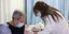 Γιατρός κάνει το εμβόλιο του κορωνοϊού σε ασθενή