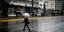 Γυναίκα περπατά με ομπρέλα στον δρόμο