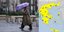 Μια γυναίκα με ομπρέλα περπατά στη βροχή