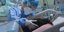 Γιατρός σε ΜΕΘ, κρατά απαλά το κεφάλι ασθενούς με κορωνοϊό