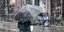 Πεζό άτομο κρατά ομπρέλα σε χιονόπτωση
