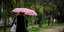 Γυναίκα περπατά με ομπρέλα σε πάρκο