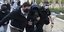 Ο Μένιος Φουρθιώτης με κουκούλα στο πρόσωπο προσάγεται από 2 αστυνομικούς   
