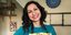 Η συγγραφέας βιβλίων μαγειρικής Γιασμίν Καν με χρωματιστή ποδιά χαμογελά