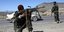 Δυο στρατιώτες με όπλα σε δρόμο στο Αφγανιστάν στο πλάι ενός αυτοκινήτου