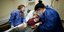 Δυο γυναίκες γιατροί πάνω σε ασθενή με κορωνοϊό που είναι σε κρεβάτι νοσοκομείου στη Αργεντινή 