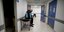 Ασθενης καθισμένος με σκυμμένο κεφάλι σε φορείο με έκδηλη την απογοήτευση σε νοσοκομείο της Αργεντινής