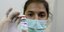 Γυναίκα γιατρός δείχνει φιαλίδιο εμβολίου της AstraZeneca 