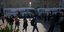 Κόσμος στην πλατεία του Σαντιάγκο στη Χιλή με παρκαρισμένα πούλμαν στο βάθος