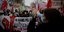 Διαδηλωτές με πανό, σημαίες, πλακάτ και γυναίκα με ντουντούκα σε διαδήλωση στη Γαλλία 