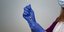 βελόνα σε εμβόλιο για κορωνοϊό στα χέρια νοσηλεύτριας με μπλε γάντια