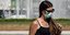 κοπέλα με μάσκα και γυαλιά κοτά σε συντριβάνι στην Αθήνα