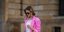 Γυναίκα περπατά με ροζ σακάκι