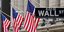 Ταμπέλα της Wall Street με αμερικανικές σημαίες στο βάθος