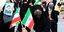 γυναίκες σε διαδήλωση με σημαίες και πλακάτ για εκλογές σε Ιράν