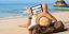 Ανδρας στην παραλία παρακολουθεί το tablet του
