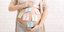 έγκυος με αυτοκόλλητα με ερωτηματικά στην κοιλιά