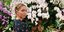 Η Μαρία Ολυμπία σε κήπο με φόντο ορχιδέες