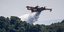 αεροπλάνο ρίχνει νερό σε φωτιά σε δάσος