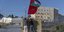 Δύο άτομα διαμαρτύρονται κρατώντας στα χέρια τους τη σημαία της Παλαιστινιακής Αρχής