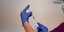 εμβόλιο σε χέρια νοσηλεύτριας με μπλε γάντια